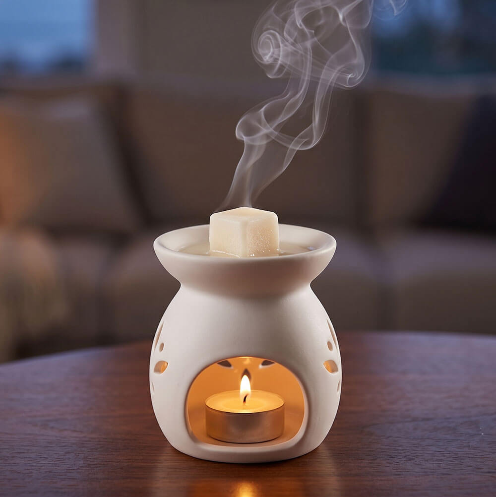 Kostka zapachowa o aromacie soli morskiej i mchu umieszczona w miseczce ceramicznego kominka aromaterapeutycznego.